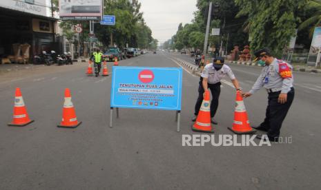 Petugas Dinas Perhubungan menutup jalan Siliwangi, Kota Cirebon, Jawa Barat, Sabtu (10/10/2020). Pemkot Cirebon memberlakukan kebijakan Pembatasan Aktivitas Masyarakat dengan menutup beberapa jalan protokol untuk mencegah penyebaran  COVID-19. 