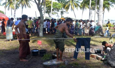 Imigran etnis Rohingya antre untuk mendapatkan pembagian makananan saat berada di tenda penampungan sementara  kawasan  pesisir pantai desa Kulam, Kecamatan Batee, Kabupaten Pidie, Aceh,  Rabu (22/11/2023). Sebanyak 240 imigran etnis Rohingya gelombang ketiga yang terdampar di daerah itu dipindahkan dari pemukiman penduduk ke daerah pesisir dengan fasilitas tempat tinggal tenda penampungan sementara karena kapasitas kamp pungungsi imigran di Minara Raya kabupaten Pidie telah melebihi kapasitas.  