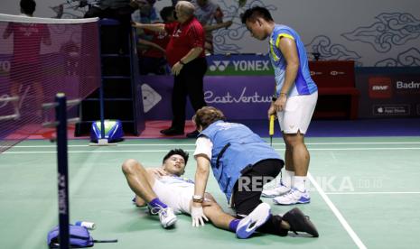 Yeremia Erich Yoche Yacob Rambitan (kiri) dari Indonesia menerima perawatan medis saat rekan setimnya Pramudya Kusumawardana (kanan) terlihat selama pertandingan perempat final ganda putra melawan Aaron Chia dan Soh Wooi Yik dari Malaysia di turnamen bulu tangkis Indonesia Open 2022 di Jakarta, Indonesia, 17 Juni 2022.