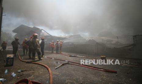 Sejumlah petugas pemadam kebakaran berupaya memadamkan api yang membakar pabrik produksi tas dari bahan sponbold di kawasan Jalan Raya Sidorejo Krian, Sidoarjo, Jawa Timur, Ahad (15/9/2024). Sebanyak 20 unit mobil pemadam kebakaran dikerahkan untuk mengatasi kebakaran yang terjadi sekitar pukul 08.00 tersebut, dan saat ini polisi masih menyelidiki penyebab kebakaran. 