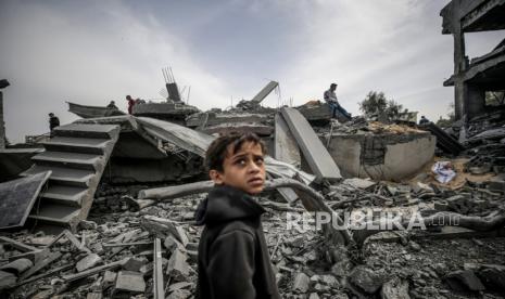 Seorang warga Palestina menyaksikan pencarian orang hilang menyusul serangan udara Israel, di kamp pengungsi Al-Maghazi, Jalur Gaza selatan, (29/3/2024).