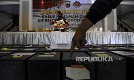 Petugas kepolisian merapikan barang bukti saat konferensi pers pengungkapan kasus pinjaman online di Mapolda Jabar, Jalan Soekarno Hatta, Kota Bandung, Kamis (21/10). Dit Reskrimsus Polda Jabar berhasil mengungkap kasus pinjaman online ilegal dengan mengamankan delapan orang tersangka dan barang bukti berupa puluhan perangkat komputer, laptop dan ponsel. Dari kasus tersebut, polisi menjerat dengan sembilan pasal diantaranya UU ITE, UU Perlindungan Konsumen dan Tindak Pidana Pencucian Uang dengan ancaman hukuman 10 tahun penjara. Foto: Republika/Abdan Syakura