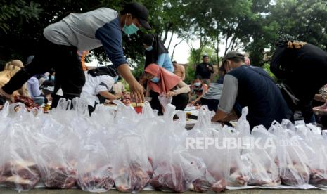 Sejumlah panitia pemotongan hewan kurban memotong dan membagi daging di halaman SMA Negeri 1 Palembang, Sumatera Selatan, Rabu (21/7/2021). Pada perayaan hari raya kurban yang bertepatan dengan pelaksanaan PPKM, Pemotongan dan pembagian kurban di lingkungan sekolah diperbolehkan untuk dilakukan dengan penerapan protokol kesehatan,pembatasan kepanitiaan, dan pembagian secara door to door. 