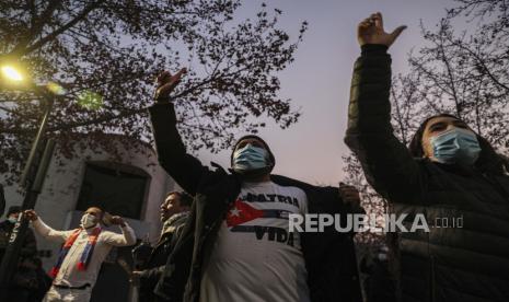 Warga Kuba yang tinggal di Chili meneriakkan slogan-slogan menentang pemerintah negara mereka selama protes di luar Kedutaan Besar Kuba di Santiago, Chili, Rabu, 14 Juli 2021. Protes itu terjadi setelah protes akhir pekan yang jarang terjadi terhadap rezim komunis di negara pulau itu.