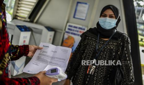 Petugas memeriksa surat tanda registrasi pekerja (STRP) atau surat tugas calon penumpang di Halte Transjakarta Gelora Bung Karno, Jakarta, Rabu (14/7). PT Transportasi Jakarta (Transjakarta) mewajibkan seluruh penumpang untuk membawa STRP atau surat tugas mulai Rabu (14/7), selama masa pemberlakuan pembatasan kegiatan masyarakat (PPKM) darurat. Republika/Putra M. Akbar