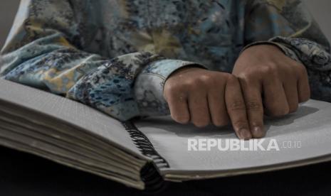 Lembaga coaching, Hijrah Coach, mengumpulkan donasi untuk memberikan wakaf sebanyak 100 set Alquran Braille. Foto: Siswa penyandang disabilitas membaca Alquran Braille. 