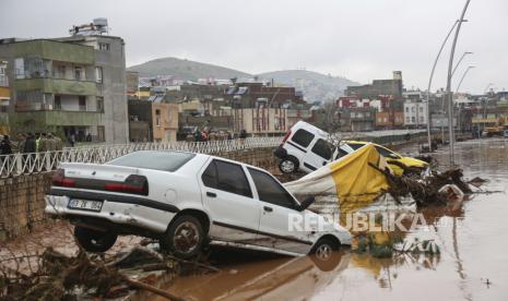  Mobil dan puing berserakan saat banjir usai hujan deras di Sanliurfa, Turki, Rabu (15/3/2023). Banjir akibat hujan deras melanda dua provinsi yang porak poranda akibat gempa bulan lalu, menewaskan sedikitnya 10 orang dan menambah kesengsaraan bagi ribuan orang. kehilangan tempat tinggal, pejabat dan laporan media mengatakan Rabu. Sedikitnya lima orang lainnya dilaporkan hilang.