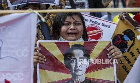 Para pengunjuk rasa mengangkat plakat di depan Bank Sentral selama protes terhadap kudeta militer di Yangon, Myanmar, 16 Februari 2021. Junta militer Myanmar pada 16 Februari menghentikan layanan internet untuk hari kedua berturut-turut, karena protes terus berlanjut meskipun pasukan dan pasukan telah dikerahkan. kendaraan lapis baja di kota-kota besar.