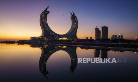 Sebuah pesawat terbang di atas Crescent Tower Lusail saat matahari terbit di Lusail, Qatar, Kamis, 24 November 2022.