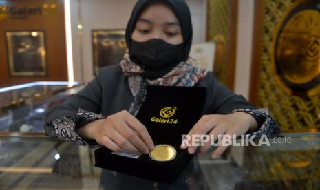 Pegawai menunjukkan emas Pegadaian di Galeri 24 Pegadaian, Jakarta, Senin (26/12/2022). Harga emas diprediksi akan terus mengalami kenaikan hingga akhir tahun 2022 dan 2023 ini. Ada banyak faktor yang mendorong logam mulia tersebut terus menguat salah satunya masalah ekonomi. Republika/Prayogi