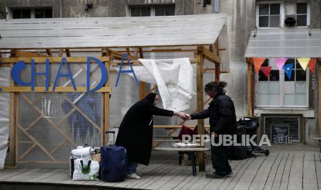 Para tunawisma berbagi makanan di tempat penampungan Aurore yang ditujukan untuk para tunawisma dan migran di Paris, Kamis (2/4). Di tengah-tengah kebijakan lockdown di Prancis akibat virus corona, pekerja amal di asosiasi Aurore Prancis menyiapkan lebih dari seribu makanan sehari untuk para migran dan para tunawisma. Jumlah kematian akibat wabah corona di Prancis naik perlahan. Ilustrasi.