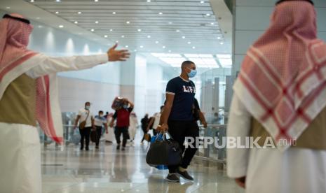 Petugas mengarahkan jamaah yang tiba di Makkah, Arab Saudi. Mereka akan menjalani empat hari karantina di hotel-hotel yang ditunjuk sebelum menjalani ibadah haji.