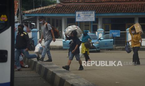 Sejumlah calon penumpang berjalan menuju bus di Terminal Bis Kota Serang, Banten, Jumat (10/4). Masyarakat Transportasi Indonesia (MTI) menyebutkan masih ada 1,3 juta orang terutama yang tinggal di Jakarta, Bogor, Depok, Tangerang, dan Bekasi (Jabodetabek) untuk melakukan tradisi mudik. Sejumlah daerah terancam menjadi pusat penularan baru. Saat ini, sudah 900 ribu orang yang mudik ke kampung halaman mereka