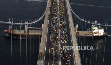  Kapal kargo curah Rattana Naree, yang berangkat dari pelabuhan Yuzhne, Ukraina, berlayar di bawah jembatan Martir 15 Juli di atas Bosphorus saat pelari mengambil bagian dalam Marathon di Istanbul, Turki, Ahad, 6 November 2022. Presiden Ukraina Volodymyr Zelenskyy meminta perluasan kesepakatan ekspor biji-bijian Laut Hitam yang akan diperpanjang. 