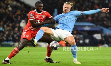 Bek Bayhern Munchen Dayot Upamecano (kiri) menjaga penyerang Manchester City Erling Haaland.