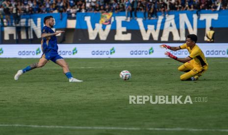 Pesepak bola Persib Bandung Marc Klok (kiri) mengejar bola dibayangi penjaga gawang PSM Makassar HIilman Syah (kanan) saat pertandingan Group A Piala Presiden 2024 di Stadion Si Jalak Harupat, Kabupaten Bandung, Jawa Barat, Jumat (19/7/2024). Persib Bandung menang atas PSM Makassar dengan skor 2-0. 