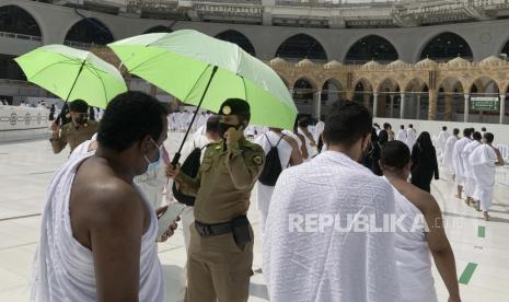 Arab Saudi Tangkap 52 Jamaah Haji Ilegal. Polisi Saudi mengawasi jamaah Muslim untuk memastikan jarak sosial untuk membantu menghentikan penyebaran virus corona, ketika mereka mengelilingi Ka