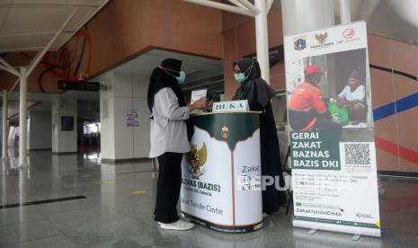 Petugas memberikan informasi tentang zakat kepada penumpang LRT di Gerai Zakat Baznas (Bazis) DKI Jakarta di Stasiun LRT Velodrome, Jakarta. BAZNAS BAZIS DKI Jakarta berhasil kembali meraih Opini Wajar Tanpa Pengecualian untuk Laporan Keuangan Tahun 2020. Ini adalah laporan keuangan tahun kedua setelah penyesuaian kelembagaan, yang semula bernama BAZIS Provinsi DKI Jakarta.