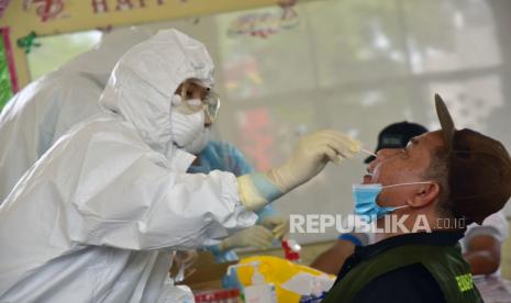 Seorang tenaga kesehatan dengan alat pelindung diri (APD) mengambil spesimen untuk swab test. Pemprov Kalteng pertimbangkan beli mobile PCR untuk optimalkan tes Covid-19. Ilustrasi. 