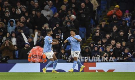 Pemain muda Manchester City Rico Lewis (kanan) merayakan dengan rekan setimnya setelah mencetak gol pertama timnya selama pertandingan sepak bola Grup G Liga Champions antara Manchester City dan Sevilla di Stadion Etihad di Manchester, Inggris, Kamis (3/11/2022) dini hari WIB.