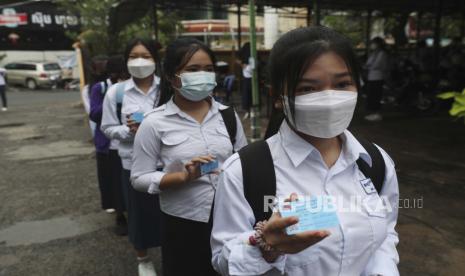  Siswa memamerkan kartu vaksinasi COVID-19 sebelum kelas pagi mereka di SMA Preah Sisowath, di Phnom Penh, Kamboja. Kamboja mulai vaksinasi anak berusia 3 dan 4 tahun dengan vaksin Covid-19 Sinovac 