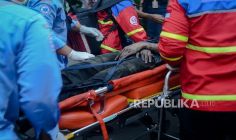 Jasad korban kebakaran dibawa dievakuasi saat terjadi kebakaran di Gedung Cyber, Jakarta, Kamis (2/12). Sebanyak 22 unit mobil pemadam dan 100 personel dikerahkan untuk memadamkan api yang diduga akibat konsleting listrik dan sebanyak tiga orang menjadi korban, dua diantaranya dinyatakan meninggal. Republik/Thoudy Badai