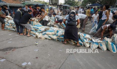 Orang-orang membangun kembali barikade setelah protes terhadap kudeta militer di Yangon, Myanmar, Kamis (18/3).. Protes anti-kudeta terus berlanjut meskipun penumpasan kekerasan yang intensif terhadap demonstran oleh pasukan keamanan.