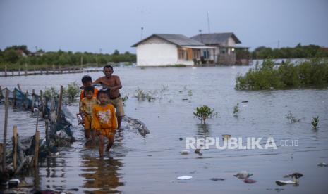 Warga menerobos banjir rob di desa Eretan Wetan, Kandanghaur, Indramayu, Jawa Barat, Senin (6/5/2024). Banjir rob tersebut mengakibatkan sejumlah rumah warga di pesisir pantai terendam setinggi 60-90 centimeter dan membuat aktivitas warga terhambat. 