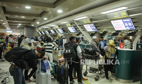 Calon penumpang mengantre untuk melakukan lapor diri (check-in) di terminal keberangkatan Bandara Internasional Sultan Hasanuddin, Maros, Sulawesi Selatan.