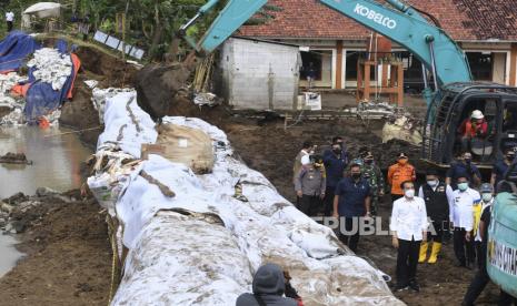 Presiden Joko Widodo (keempat kanan) didampingi Menteri PUPR Basoeki Hadimoeljono (kanan), Gubernur Jawa Barat Ridwan Kamil (ketiga kanan) dan Bupati Bekasi Eka Supria Atmaja (kedua kanan) meninjau lokasi jebolnya tanggul Sungai Citarum di Pebayuran, Kabupaten Bekasi, Jawa Barat, Rabu (24/2/2021). Akibat jebolnya tanggul Sungai Citarum tersebut menyebabkan banjir di 134 titik lokasi pada 19 kecamatan di Kabupaten Bekasi dan sebanyak 27.928 kepala keluarga terdampak banjir. 