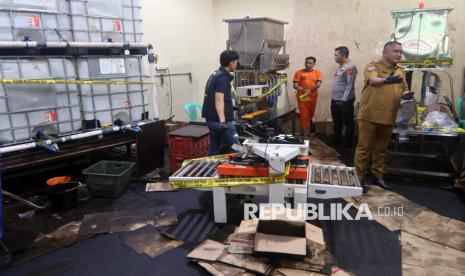 Bupati Bogor Rudy Susmanto (kanan) dan Kapolres Bogor AKBP Rio Wahyu Anggoro (kedua kanan) menyaksikan tersangka kasus pemalsuan minyak goreng, TRM (ketiga kanan) melakukan pengemasan minyak goreng dengan merek dagang MinyaKita palsu di tempat produksinya di Sukaraja, Kabupaten Bogor, Jawa Barat, Senin (10/3/2025). Polres Bogor mengungkap tempat produksi minyak goreng dengan merek dagang MinyaKita palsu dan menjadi lokasi untuk mengumpulkan minyak goreng curah yang dikemas dengan kemasan menyerupai produk bermerek MinyaKita lalu dijual seharga Rp15.600 kepada distributor di wilayah Jabodetabek. 