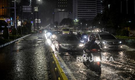 Sejumlah kendaraan melewati genangan air di kawasan Bundaran HI, Jakarta, Senin (21/9). Hujan deras yang mengguyur wilayah Ibu Kota menyebabkan genangan air di sejumlah jalan protokol sehingga menghambat laju kendaraan yang melintas. Republika/Putra M. AKbar