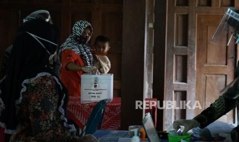 Warga memasukan struk barcode ke kotak audit saat Pemilihan Kepala Desa (Pilkades) E-Voting, di Krapyak X, Margoagung, Seyegan, Sleman, DIY, Ahad (20/12/2020).