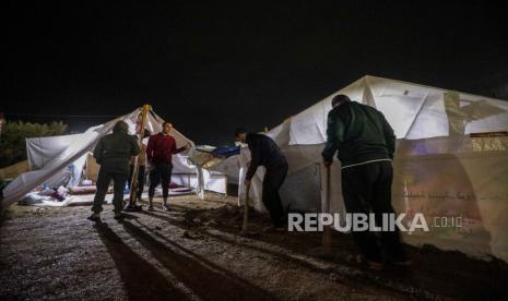 Palestinians who fled the northern Gaza Strip prepare their makeshift tents during a rainy night in Khan Younis town, southern Gaza Strip on 14 November 2023. More than 11,100 Palestinians and at least 1,200 Israelis have been killed, according to the Israel Defense Forces (IDF) and the Palestinian health authority, since Hamas militants launched an attack against Israel from the Gaza Strip on 07 October, and the Israeli operations in Gaza and the West Bank which followed it.  