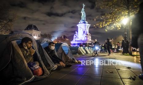  Seorang migran duduk di tendanya ketika ratusan migran dan pengungsi dievakuasi dari kamp migran darurat di Saint-Denis pada 17 November, memasang tenda dengan dukungan asosiasi dan organisasi di Republic Square di Paris, Prancis, 23 November 2020.