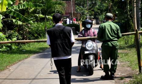 Satgas Covid-19 menginterogasi warga yang akan keluar saat karantina wilayah di Pedukuhan Ngino XII, Seyegan, Sleman, Yogyakarta, Jumat (18/6). Sebanyak 250 KK dari empat RT harus menjalani karantina wilayah usai ada warga positif Covid-19 pascaziarah. Satgas Covid-19 Kalurahan Margoagung berjaga di gerbang masuk desa untuk melarang warga keluar lokasi.