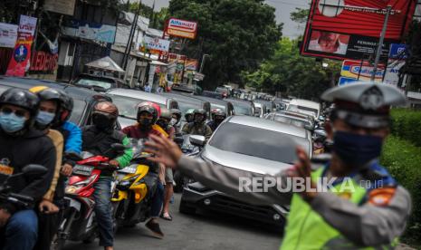 Anggota kepolisian mengatur arus lalu lintas menuju kawasan wisata Lembang di Jalan Setiabudi, Bandung, Jawa Barat, Kamis (29/10/2020). Pada cuti bersama serta libur panjang Maulid Nabi Muhammad SAW hari kedua, jalur wisata menuju Lembang dipadati kendaraan wisatawan, dan kepolisian memberlakukan pengalihan arus untuk mengurai kemacetan. 