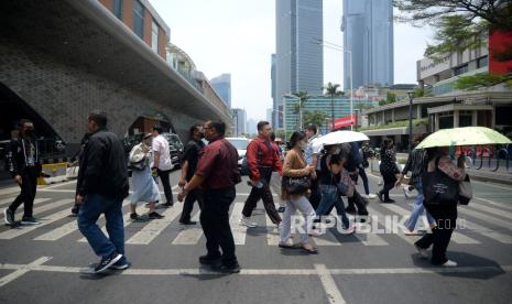 Warga berjalan saat berlangsungnya fenomena alam kulminasi utama matahari di Kawasan Bundaran HI, Jakarta, Senin (9/10/2023). 