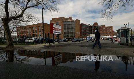 Seorang pria yang mengenakan masker melewati the di Kingsbrook Jewish Medical Center, di Brooklyn, New York, AS, Rabu (8/4).