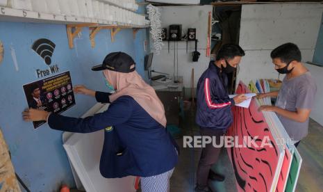 Mahasiswa yang menjadi relawan menempelkan poster adaptasi kebiasaan baru (Ilustrasi). Direktorat Jenderal Pendidikan Tinggi (Ditjen Dikti) Kementerian Pendidikan dan Kebudayaan (Kemendikbud) mengalokasikan dana Rp 405 miliar terkait program penanganan Covid-19 seperti Mahasiswa Relawan.