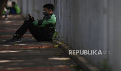 Pengemudi ojek daring menunggu orderan di kawasan Tanah Kusir, Jakarta.  Salah satu asosiasi ojek daring, Gabungan Aksi Roda Dua (Garda), memastikan kendaraan higienis saat digunakan untuk mengangkut penumpang menghadapi normal baru atau new normal.