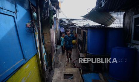 Warga melintasi lorong hunian yang berada diatas laut di kawasan Penjaringan, Jakarta Utara, Senin (30/1/2023). 