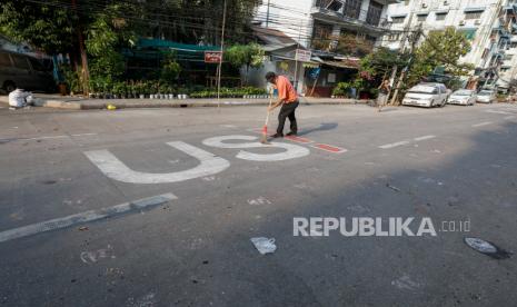 warga membersihkan jalan setelah protes terhadap kudeta militer di Yangon, Myanmar. ilustrasi