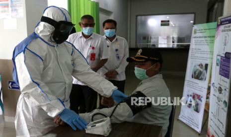 Petugas medis Rumah Sakit Umum Daerah (RSUD) Meuraxa menggunakan Alat Pelindung Diri (APD) untuk penanganan pasien yang diduga terinfeksi virus Corona (COVID-19) memeriksa tensi darah warga di Banda Aceh, Aceh, Rabu (18/3/2020).(Antara/Irwansyah Putra)