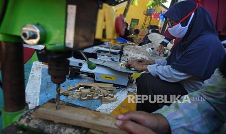 Ibu rumah tangga mengolah kayu limbah memakai mesin gergaji scroll saw untuk dijadikan mainan dalam program Usaha Mandiri Lingkungan di Kampung Pipiatan, Walantaka, Serang, Banten, Selasa (25/8/2020). Pemda setempat bekerja sama dengan Kemenetrian Koperasi dan UKM menggulirkan program tersebut dengan menyediakan pinjaman bantuan modal hingga Rp30 juta per kelompok usaha guna menambah penghasilan warga terdampak COVID-19. 