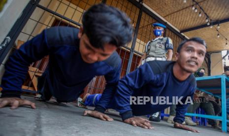 Petugas Satpol PP memberikan sanksi push up kepada pelanggar karena tidak menggunakan masker.