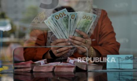 Petugas menghitung uang dollar AS di tempat penukaran valuta asing PT Valuta Inti Prima di Cikini, Jakarta, Selasa (21/11/2023). 