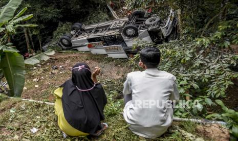 Warga menyaksikan kondisi bangkai bus pariwisata PO Sri Padma Kencana pascakecelakaan di kawasan Tanjakan Cae, Jalan Raya Wado-Malangbong, Kabupaten Sumedang, Kamis (11/3). Kecelakaan tunggal bus pariwisata PO Sri Padma Kencana dengan no pol T 7591 TB yang membawa rombongan peziarah dari sebuah sekolah tersebut mengakibatkan 27 penumpang bus meninggal dunia dan 39 penumpang selamat. Foto: Republika/Abdan Syakura