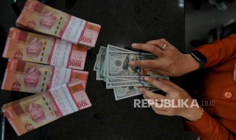 Petugas menghitung uang dollar AS di tempat penukaran valuta asing PT Valuta Inti Prima di Cikini, Jakarta, Selasa (21/11/2023). 