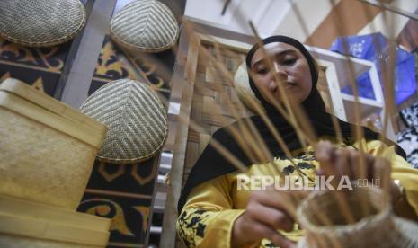 Perajin menyelesaikan pembuatan kerajinan anyaman rotan di stan Dekranasda Aceh Besar saat pameran Kriyanusa 2022 di Jakarta Convention Center, Senayan, Jakarta, Jumat (23/9/2022). Dewan Kerajinan Nasional (Dekranas) menggelar pameran Kriyanusa yang memamerkan produk-produk kerajinan unggulan dari berbagai daerah serta menghadirkan beberapa pengrajin yang dapat dilihat langsung oleh pengunjung saat membuat produk kerajinan. 